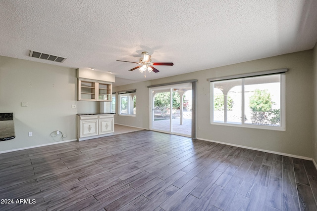 unfurnished living room with ceiling fan, wood-type flooring, and a textured ceiling