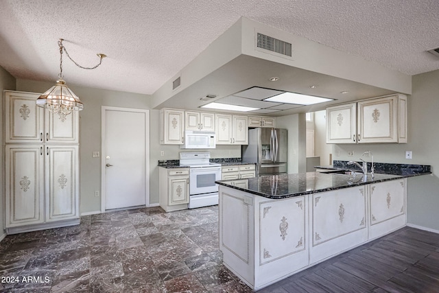 kitchen featuring kitchen peninsula, sink, pendant lighting, and white appliances