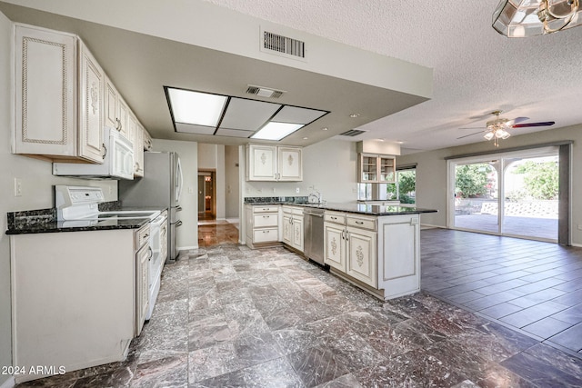 kitchen with white appliances, sink, ceiling fan, a textured ceiling, and kitchen peninsula