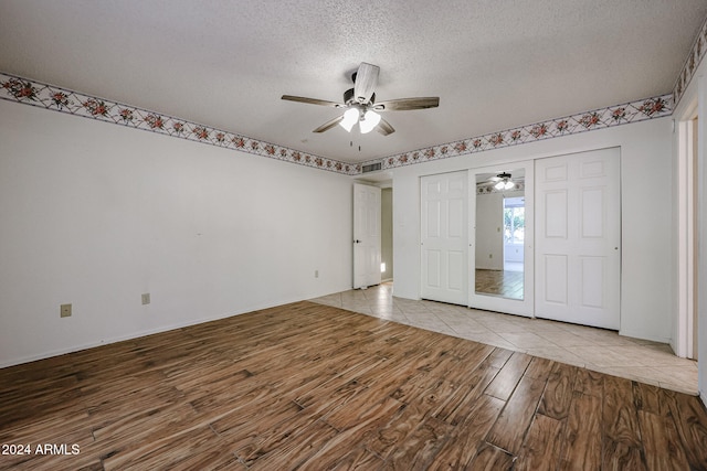 interior space with a textured ceiling, light hardwood / wood-style flooring, and ceiling fan