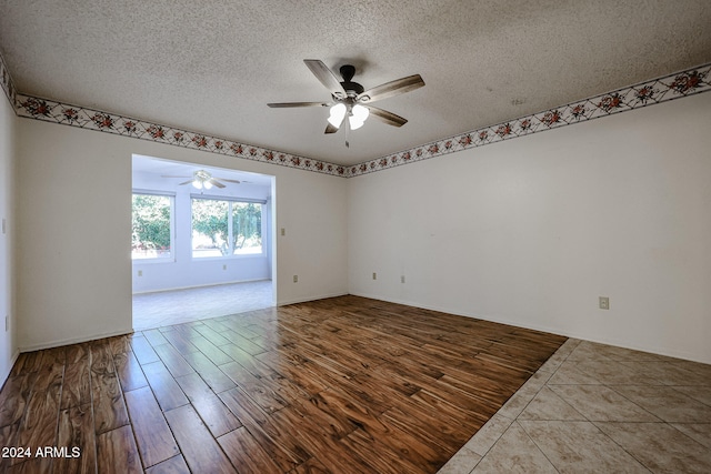 spare room with hardwood / wood-style flooring, ceiling fan, and a textured ceiling