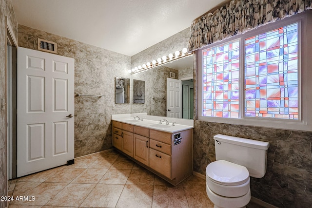 bathroom with toilet, vanity, tile patterned floors, and plenty of natural light