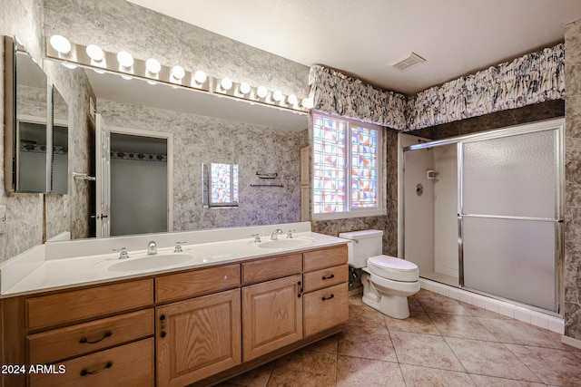 bathroom featuring tile patterned flooring, vanity, toilet, and a shower with shower door