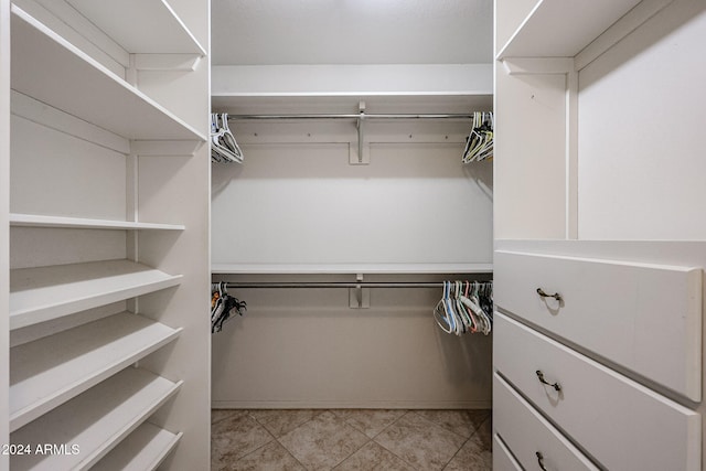 walk in closet with light tile patterned flooring