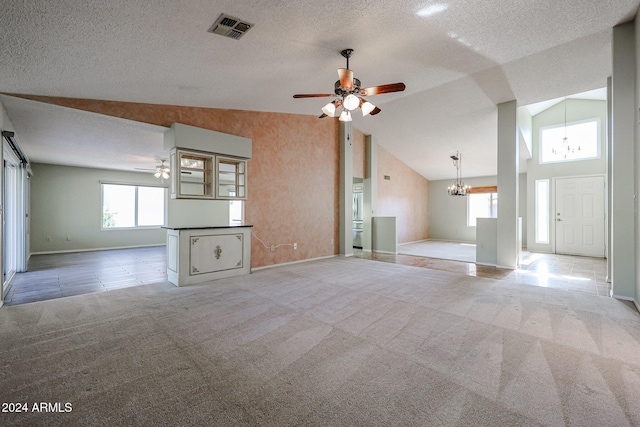 unfurnished living room with ceiling fan with notable chandelier, light colored carpet, a textured ceiling, and high vaulted ceiling