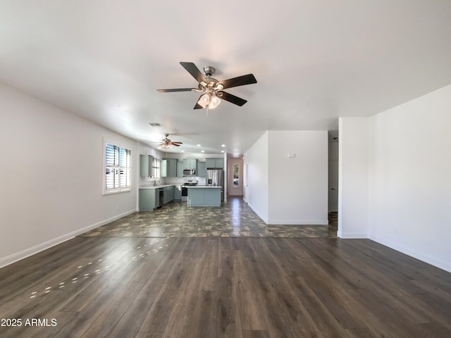 unfurnished living room with sink, ceiling fan, and dark hardwood / wood-style flooring