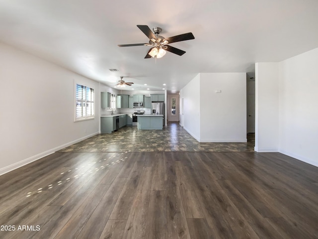 unfurnished living room with sink, ceiling fan, and dark wood-type flooring