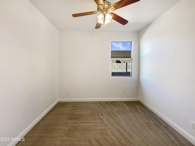 spare room with dark colored carpet and ceiling fan