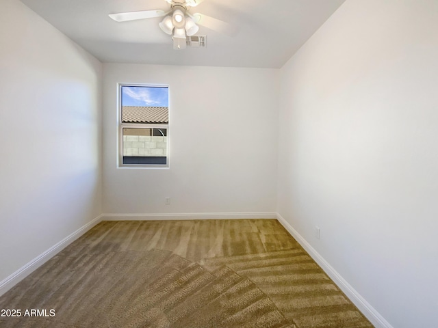 empty room featuring ceiling fan and carpet