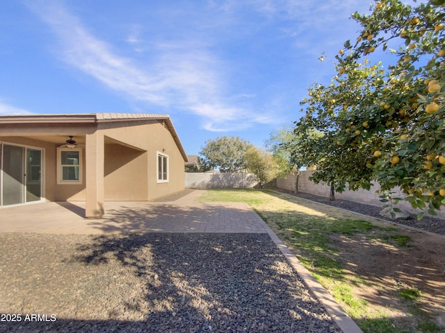 view of yard featuring a patio area and ceiling fan