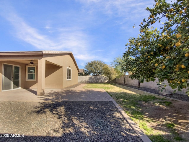 view of yard with ceiling fan and a patio