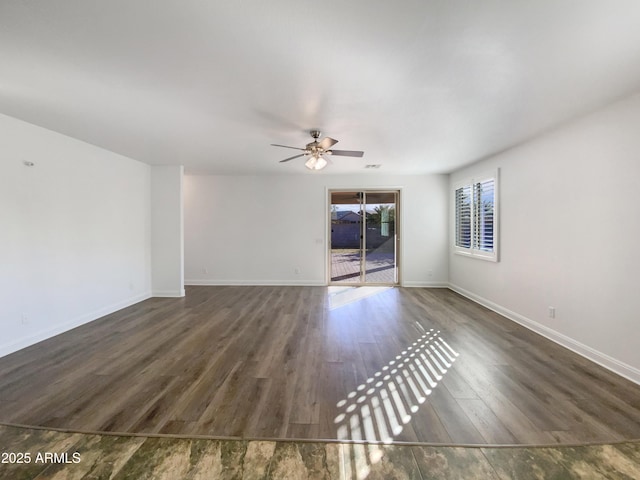 empty room with ceiling fan and dark hardwood / wood-style floors