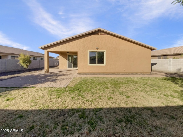 rear view of property with a yard and a patio