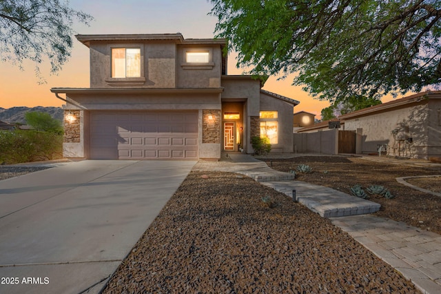 1834 W Nighthawk Way, Phoenix, AZ 85045 - view of front of property featuring a garage, concrete driveway, stone siding, and stucco siding