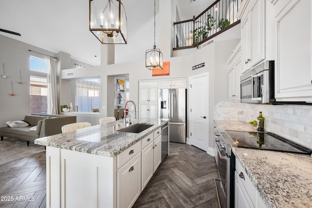 1834 W Nighthawk Way, Phoenix, AZ 85045 - kitchen featuring appliances with stainless steel finishes, a sink, a chandelier, white cabinetry, and a towering ceiling