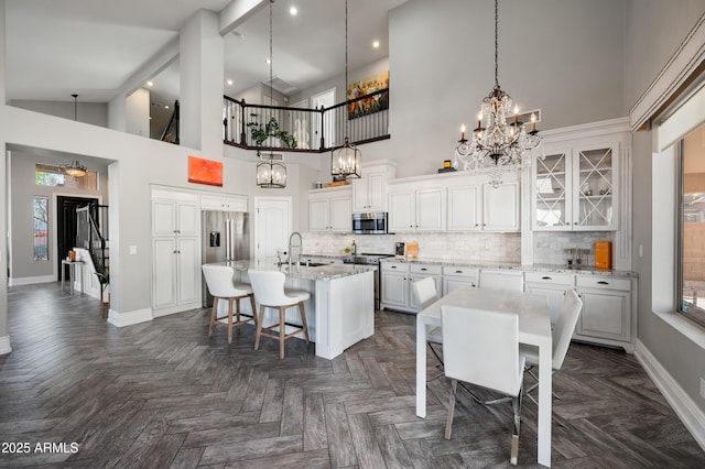 1834 W Nighthawk Way, Phoenix, AZ 85045 - kitchen with a chandelier, a sink, a center island with sink, appliances with stainless steel finishes, and a high ceiling