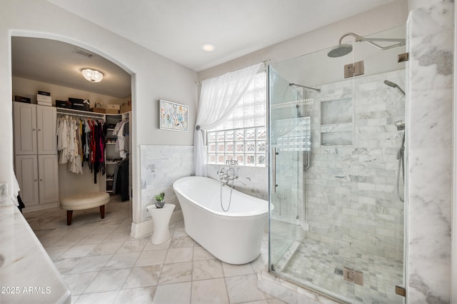 1834 W Nighthawk Way, Phoenix, AZ 85045 - full bathroom featuring a stall shower, a freestanding bath, a walk in closet, and marble look tile flooring