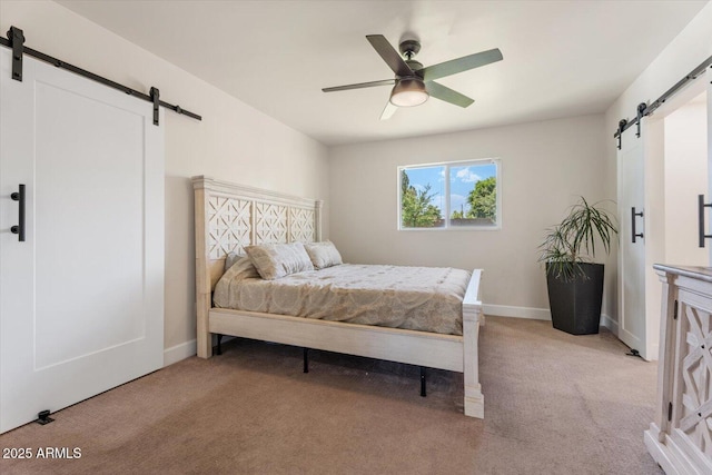 bedroom featuring baseboards, ceiling fan, light carpet, and a barn door