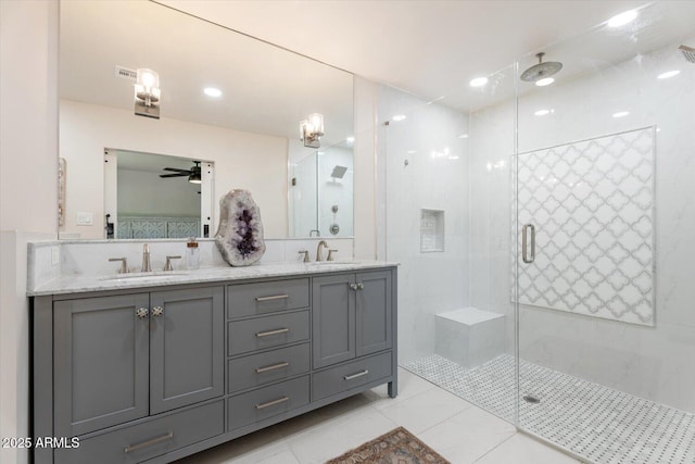 bathroom with double vanity, a sink, tile patterned flooring, and a stall shower