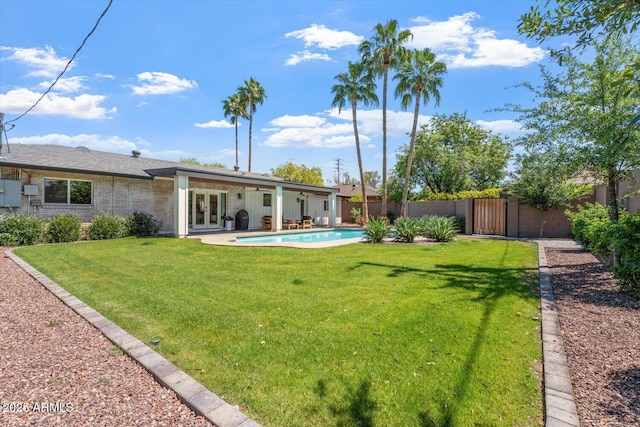 view of yard with fence private yard, french doors, a fenced in pool, a gate, and a patio area