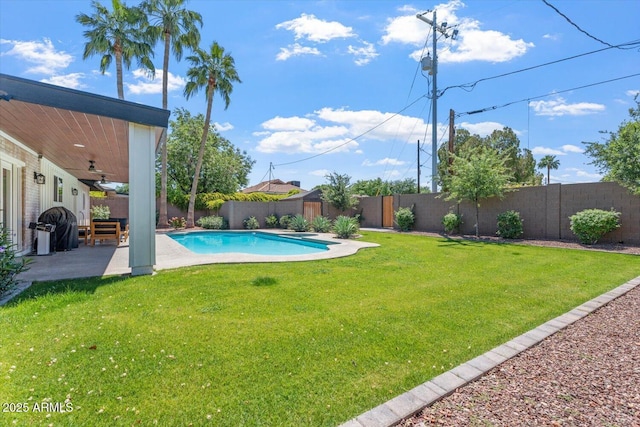 view of swimming pool with a yard, ceiling fan, a fenced in pool, and a fenced backyard