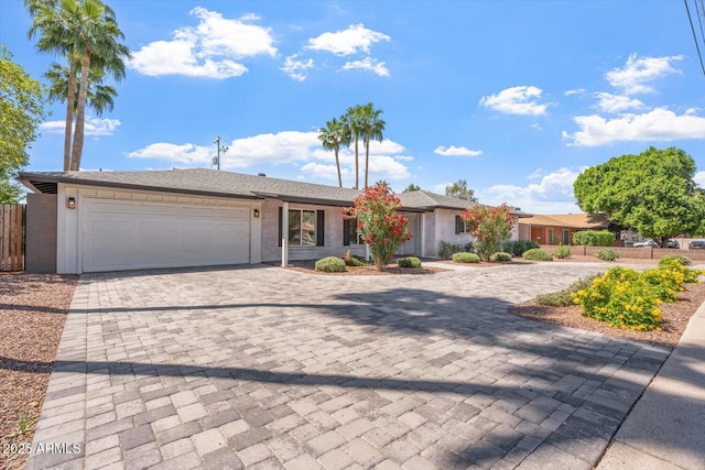 ranch-style house featuring fence, decorative driveway, and a garage