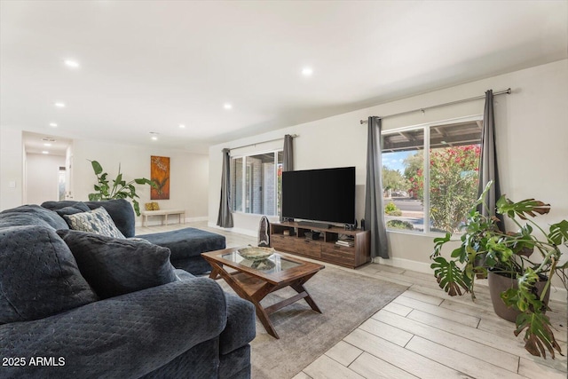 living area with a healthy amount of sunlight, wood tiled floor, and recessed lighting