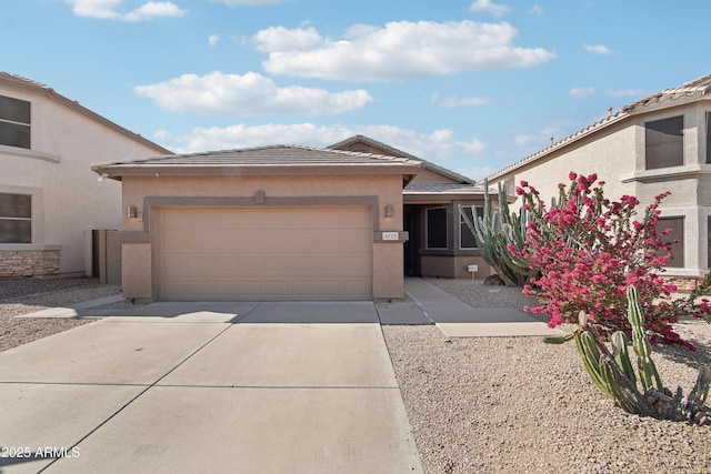 view of front of property with a tiled roof, concrete driveway, a garage, and stucco siding