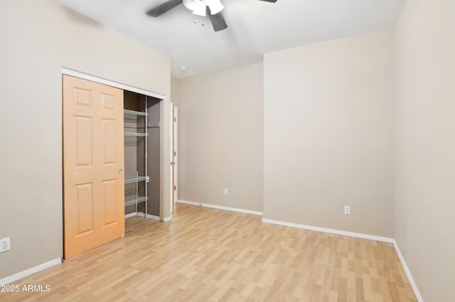 unfurnished bedroom with a closet, baseboards, light wood finished floors, and ceiling fan