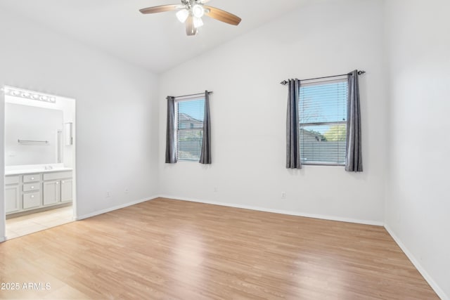unfurnished room featuring lofted ceiling, light wood-type flooring, baseboards, and ceiling fan