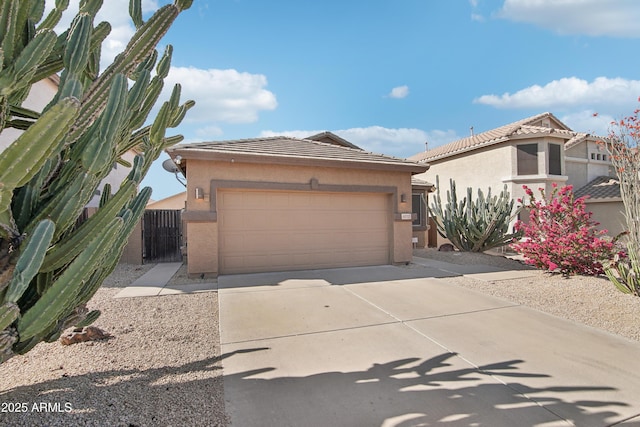 view of front of property featuring an attached garage, concrete driveway, stucco siding, and a tile roof