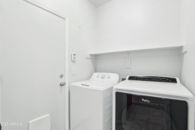 washroom with tile patterned floors, separate washer and dryer, and laundry area