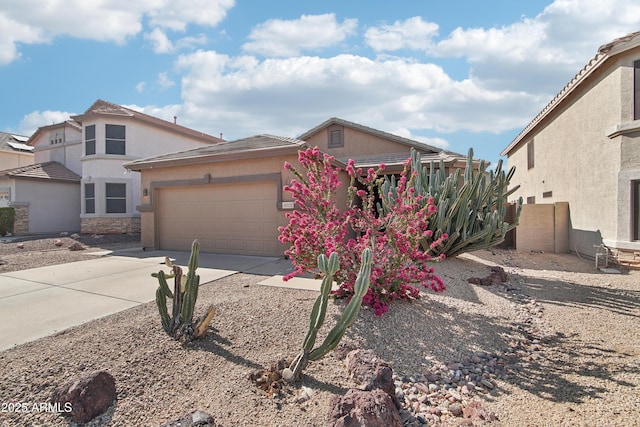 view of front facade featuring an attached garage, fence, driveway, and stucco siding