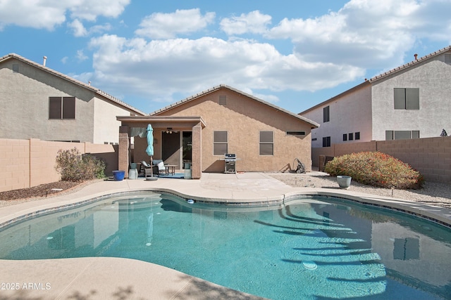 view of pool featuring a fenced in pool, area for grilling, a patio area, and a fenced backyard