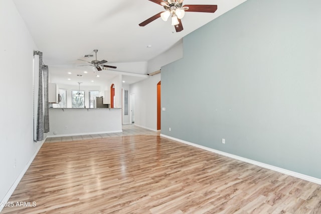 unfurnished living room featuring baseboards, arched walkways, ceiling fan, light wood-style floors, and recessed lighting