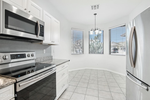 kitchen featuring a wealth of natural light, white cabinetry, an inviting chandelier, and stainless steel appliances