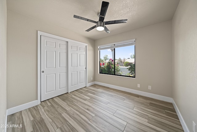2105 W Terrace Dr, Wickenburg, AZ 85390 - unfurnished bedroom with a ceiling fan, a closet, light wood-style flooring, a textured ceiling, and baseboards