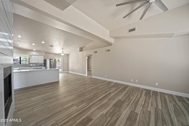 2105 W Terrace Dr, Wickenburg, AZ 85390 - unfurnished living room featuring light wood finished floors, a ceiling fan, a fireplace, lofted ceiling, and recessed lighting