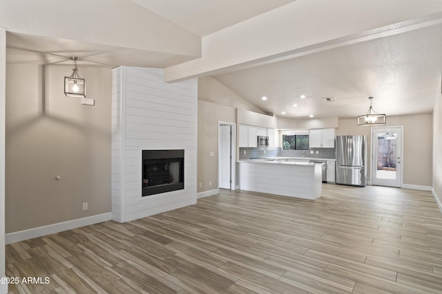2105 W Terrace Dr, Wickenburg, AZ 85390 - unfurnished living room with lofted ceiling, light wood-style floors, a large fireplace, and baseboards