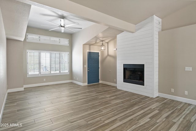 2105 W Terrace Dr, Wickenburg, AZ 85390 - unfurnished living room with baseboards, wood finished floors, a fireplace, and ceiling fan