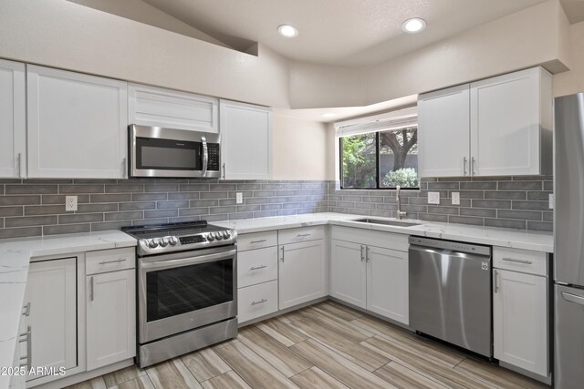 2105 W Terrace Dr, Wickenburg, AZ 85390 - kitchen featuring light wood-style flooring, a sink, stainless steel appliances, white cabinets, and light stone counters