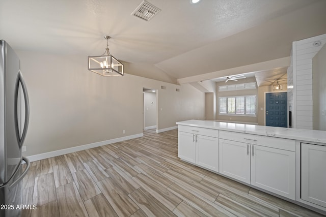 2105 W Terrace Dr, Wickenburg, AZ 85390 - kitchen with freestanding refrigerator, lofted ceiling, baseboards, visible vents, and ceiling fan with notable chandelier