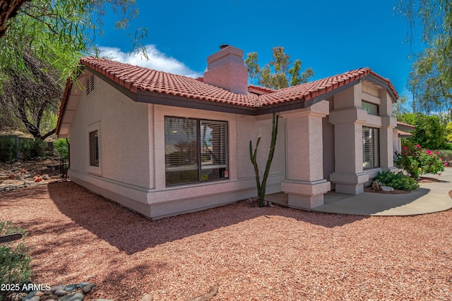 2105 W Terrace Dr, Wickenburg, AZ 85390 - rear view of property featuring stucco siding, a tile roof, and a chimney