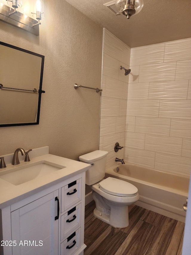 2105 W Terrace Dr, Wickenburg, AZ 85390 - bathroom featuring vanity, a textured wall, wood finished floors, toilet, and shower / bathing tub combination