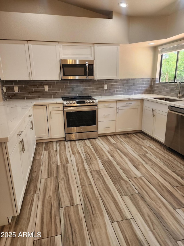 2105 W Terrace Dr, Wickenburg, AZ 85390 - kitchen with white cabinets, appliances with stainless steel finishes, decorative backsplash, and a sink