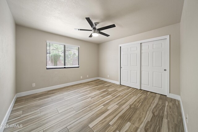 2105 W Terrace Dr, Wickenburg, AZ 85390 - unfurnished bedroom featuring a closet, baseboards, a ceiling fan, and light wood-style floors