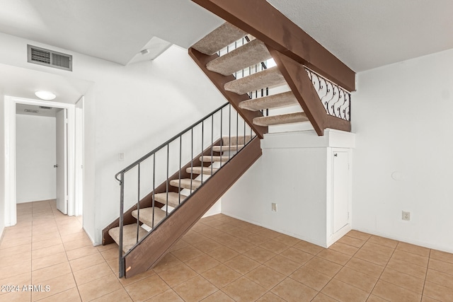 stairway featuring tile patterned flooring