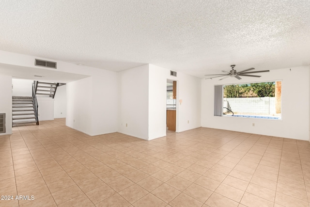 tiled spare room featuring a textured ceiling and ceiling fan