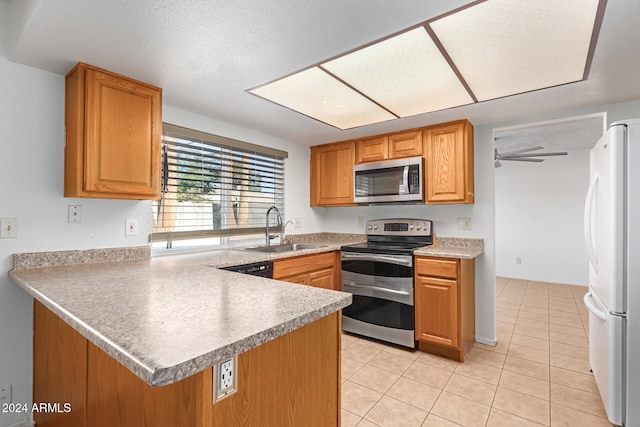 kitchen with a textured ceiling, kitchen peninsula, appliances with stainless steel finishes, and sink