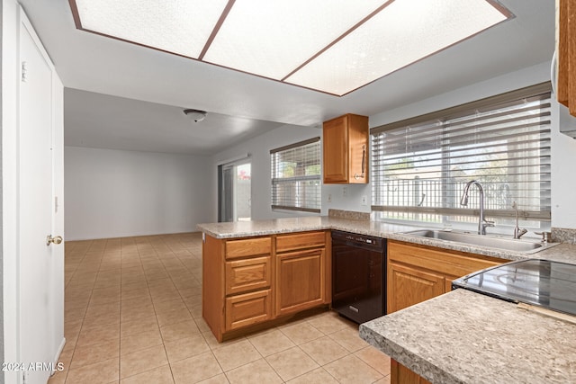 kitchen with light tile patterned floors, sink, kitchen peninsula, and black dishwasher